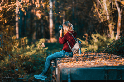 Girl taking photograph - photography is a great hobby to improve your mental health