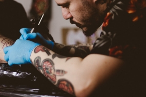 man getting inked by tattoo artist